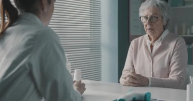 Doktor endişeli bir kıdemli hastaya yardım ediyor.