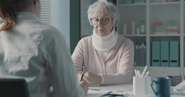 Médecin rédigeant une prescription médicale pour un patient âgé — Video