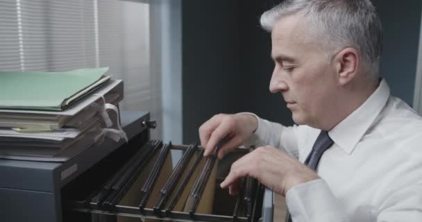 Geschäftsmann sucht nach Akten im Aktenschrank — Stockvideo