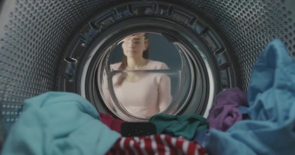 Vrouw vindt haar smartphone in de wasmachine — Stockvideo