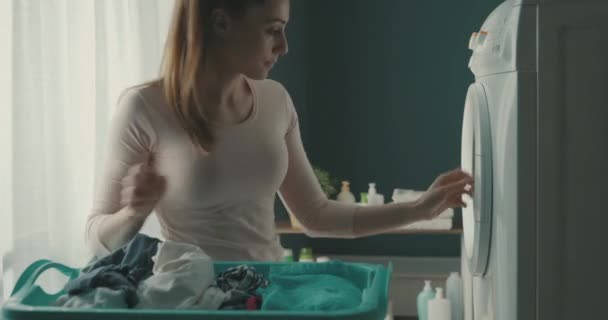 Glückliche Frau beim Beladen der Waschmaschine — Stockvideo