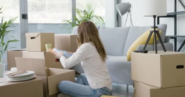 Mujer desempacando en su nuevo apartamento — Vídeo de stock