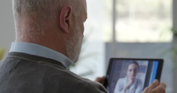 Paciente sênior tendo uma consulta de vídeo chat com seu médico — Vídeo de Stock