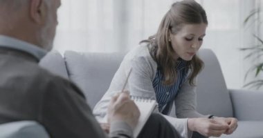 Ofiste profesyonel terapistiyle konuşan bir kadın.