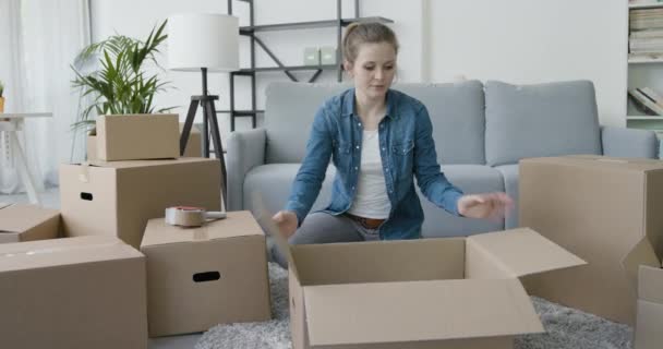 Nő csomagolás a nappaliban — Stock videók