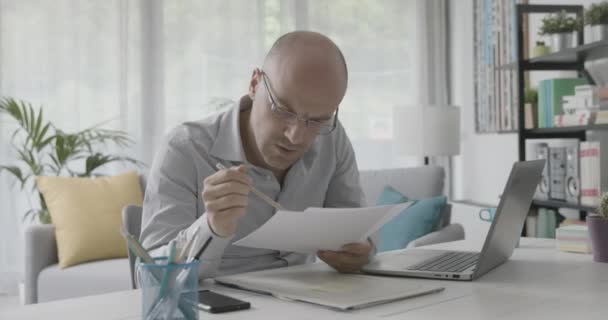 Csalódott üzletember ellenőrzi a papírokat. — Stock videók
