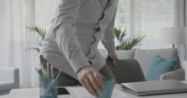 Trabajador remoto sentado en el escritorio y conectándose con una computadora portátil — Vídeo de stock