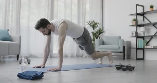 Hombre musculoso haciendo ejercicio en casa — Vídeos de Stock