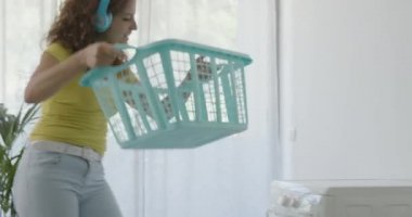 Mutlu genç kadın evde çamaşır yıkıyor.