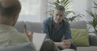 Profesyonel bir psikologla terapi seansı yapan bir adam.