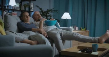 Evde televizyon izleyen sıkıcı bir çift.