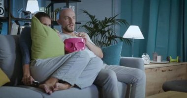 Televizyonda korku filmi izleyen bir çift.