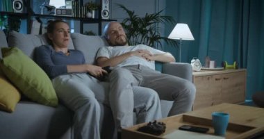 Evde televizyon izleyen sıkıcı bir çift.