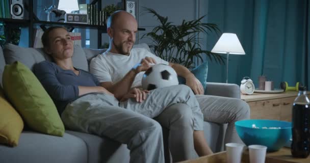 Pareja feliz viendo un partido de fútbol en la televisión — Vídeos de Stock