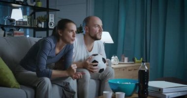 TV 'de futbol maçı izleyen mutlu çift.