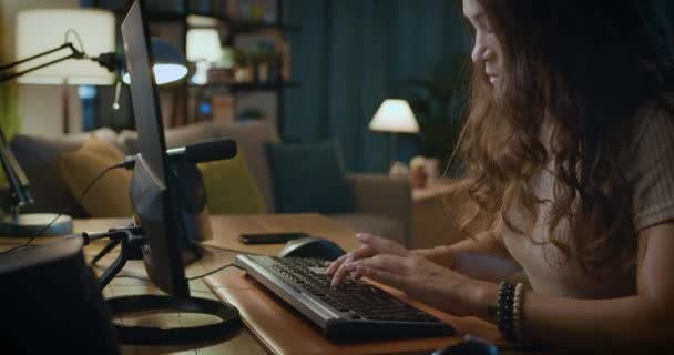 机に座ってコンピュータと接続している若い女性 — ストック動画