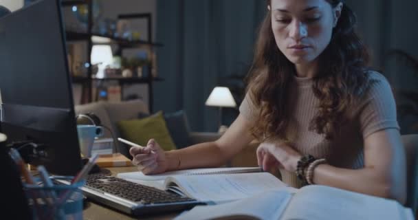 Mądra młoda kobieta uczy się do późna w nocy — Wideo stockowe