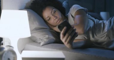 Geceleri telefonuna bağlanan uykusuz bir kadın.