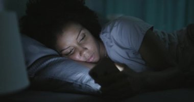 Geceleri telefonuna bağlanan uykusuz bir kadın.