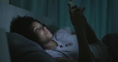 Geceleri telefonuna bağlanan uykusuz bir kadın.