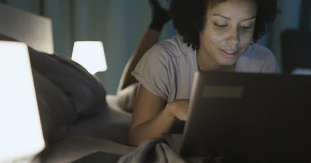 Afroamerykanka leżąca w łóżku i łącząca się ze smartfonem — Wideo stockowe
