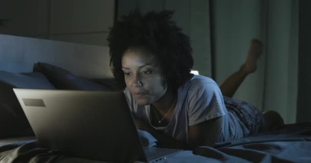 Donna afroamericana sdraiata a letto e connessa con il suo smartphone — Video Stock