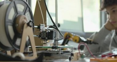 Öğrenciler laboratuarda 3D yazıcı kullanıyorlar.