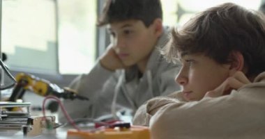Öğrenciler laboratuarda 3D yazıcı kullanıyorlar.