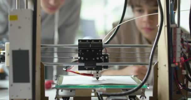 Estudiantes imprimiendo un prototipo usando una impresora 3D — Vídeo de stock