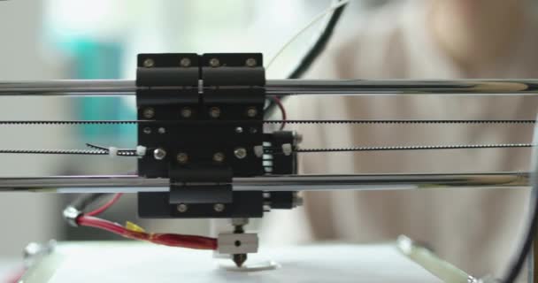 Jóvenes estudiantes mirando a la impresora 3D imprimiendo un prototipo — Vídeo de stock