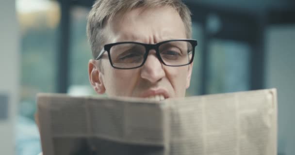 Az ember újságot olvas és látási problémái vannak. — Stock videók