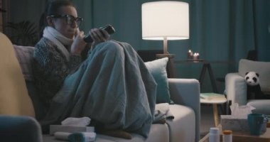 Hasta kadın kanepede oturup televizyon izliyor.