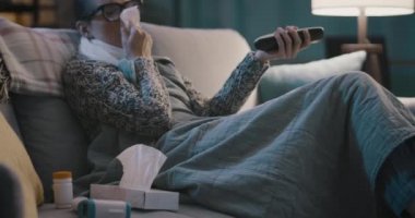 Hasta kadın evde televizyon izliyor.