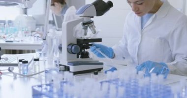 Genç araştırmacı bir örneği inceliyor.