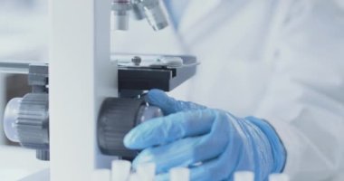 Genç araştırmacı örnekleri mikroskop altında analiz ediyor.