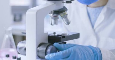 Genç araştırmacı örnekleri mikroskop altında analiz ediyor.