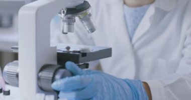 Genç araştırmacı örnekleri mikroskop altında analiz ediyor.