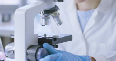 Genç araştırmacı örnekleri mikroskop altında analiz ediyor.