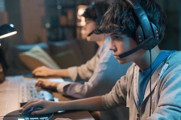 Teenager Friends Playing Online Video Games Together Wearing Headsets Staring — 스톡 사진