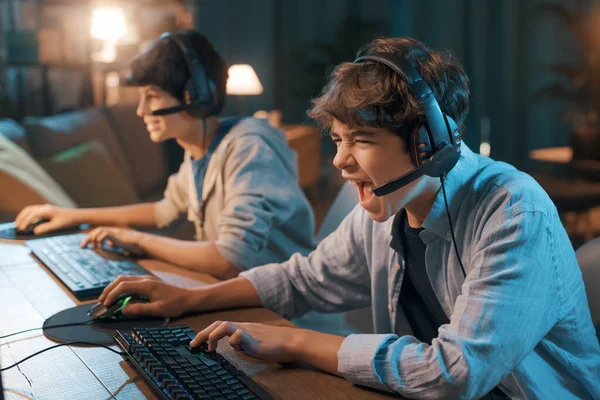 Young Gamers Sitting Desk Playing Online Video Games Together One — 스톡 사진