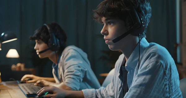 Young Gamers Wearing Headsets Playing Online Multiplayer Video Games Home — Fotografia de Stock