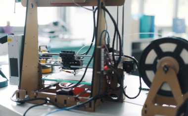 3D printer and tools on the laboratory desk: additive manufacturing, prototyping and engineering concept