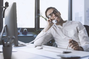 Corporate businessman sitting at desk and answering phone calls