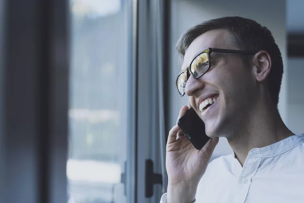 Усміхнений Бізнесмен Стоїть Поруч Вікном Має Телефонний Дзвінок Смартфоном — стокове фото