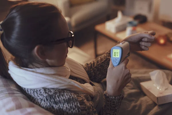 Sick Woman Resting Couch Home Measuring Her Temperature Infrared Thermometer — Foto de Stock