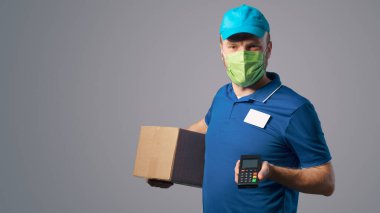 Delivery man wearing a face mask and holding a POS terminal