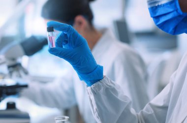 Medical research in a laboratory, a scientist is holding a vial with liquid sample