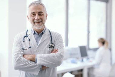 Confident doctor posing with arms crossed and smiling, healthcare and medicine concept