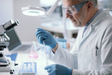 Laboratuvarda çalışan profesyonel bir tıp araştırmacısı. Örnekleri inceliyor.