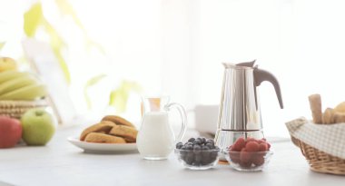 Delicious breakfast at home: fresh fruit and coffee on the kitchen table